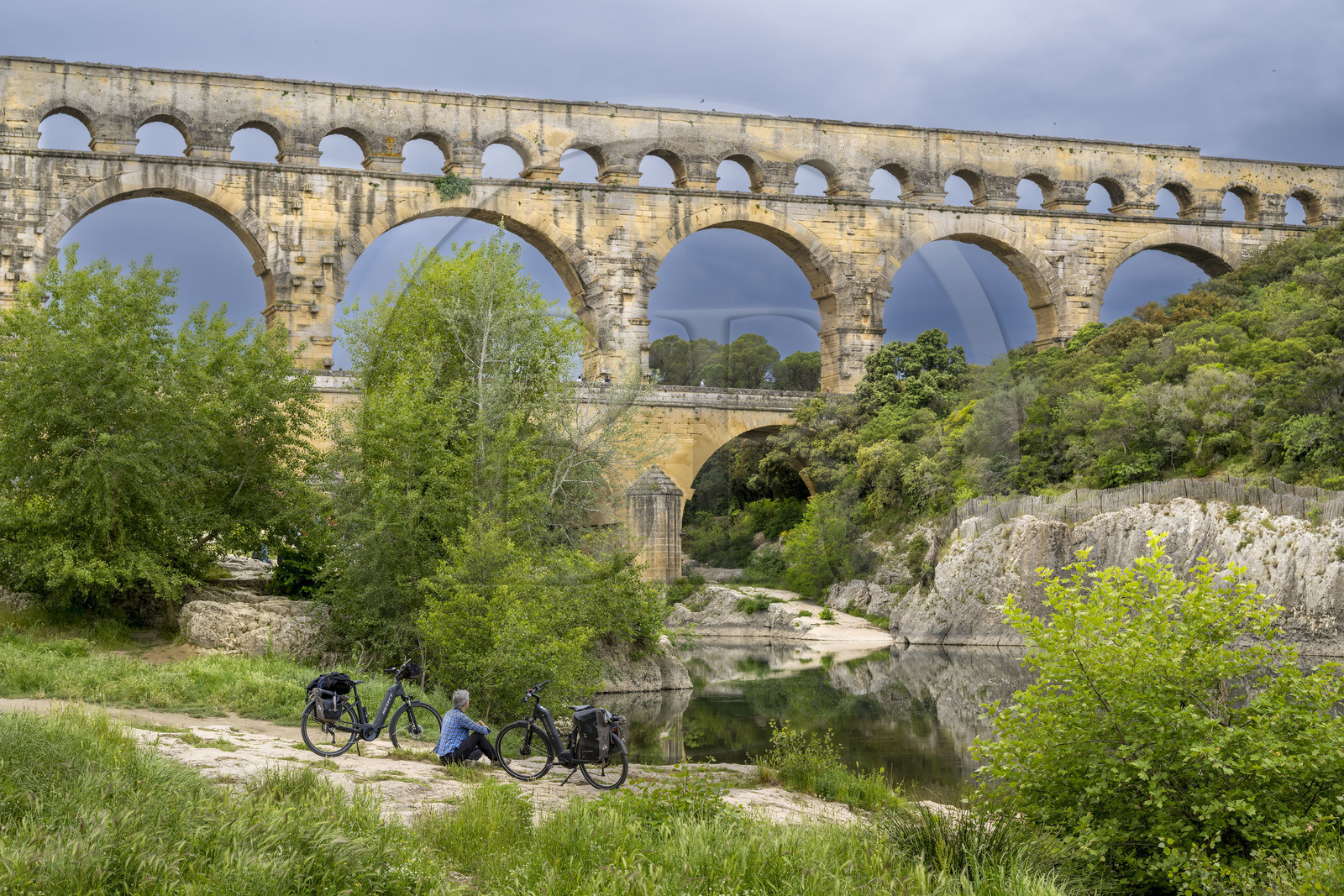 France, Gard (30), le Pont du Gard classé Patrimoine Mondial de l'UNESCO, Grand Site de France, cycliste prenant une pause devant le pont aqueduc romain qui enjambe le Gardon