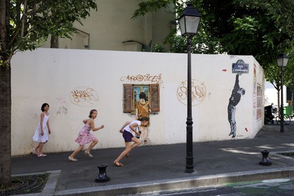 France, Paris (75), quartier de la Butte-aux-Cailles, enfants courant rue de l'Espérance sous un graffity de Lézards