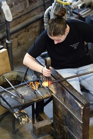 France, Moselle (57), Meisenthal, Centre international d’Art verrier (CIAV), l'atelier de soufflage, fabrication artisanale d'une boule de Noël, le souffleur régularise la masse au marbre tout en effectuant une rotation continue de sa canne et préparation de la paraison avant le passage au moule
