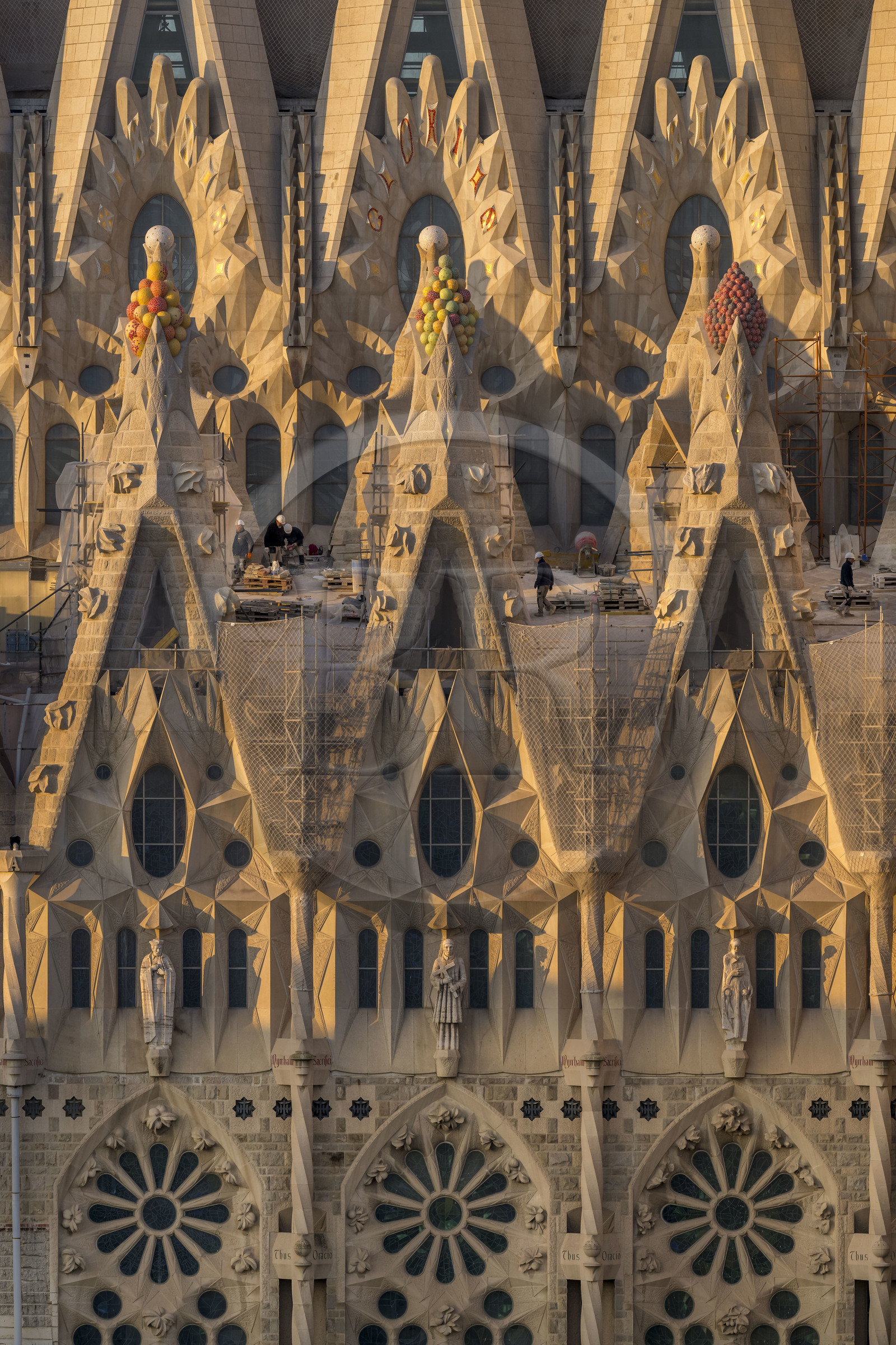 Espagne, Catalogne, Barcelone, quartier de l'Eixample, basilique de la Sagrada Familia de l'architecte du modernisme catalan Antoni Gaudi classée Patrimoine Mondial de l'UNESCO, sommets surmontés de mosaïques en forme de fruits entourant le chantier sur le toit de la nef ici côté facade de la Passion
