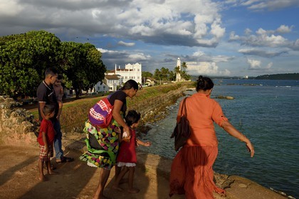 Sri Lanka, Province du Sud, Fort de Galle, classé Patrimoine Mondial de l'UNESCO, famille sur les remparts maritimes de la ville fortifiée, la mosquée Meera et le phare en arrière plan