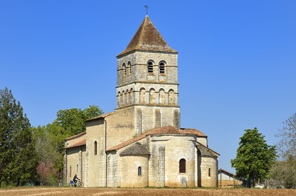 France, Dordogne (24), Périgord Vert, Javerlhac-et-la-Chapelle-Saint-Robert, cycliste faisant la véloroute La Flow Vélo devant le chevet de l'église romane XIIème siècle de La Chapelle-Saint-Robert, église de l'ancien prieuré fondé par un disciple du premier abbé de la Chaise-Dieu Robert de Turlande