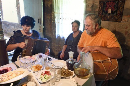 Géorgie, Kakheti, Akhmeta, repas traditionnel de fête dans une famille de Touchétie, chants accompagnés de l'accordéon et du tambour