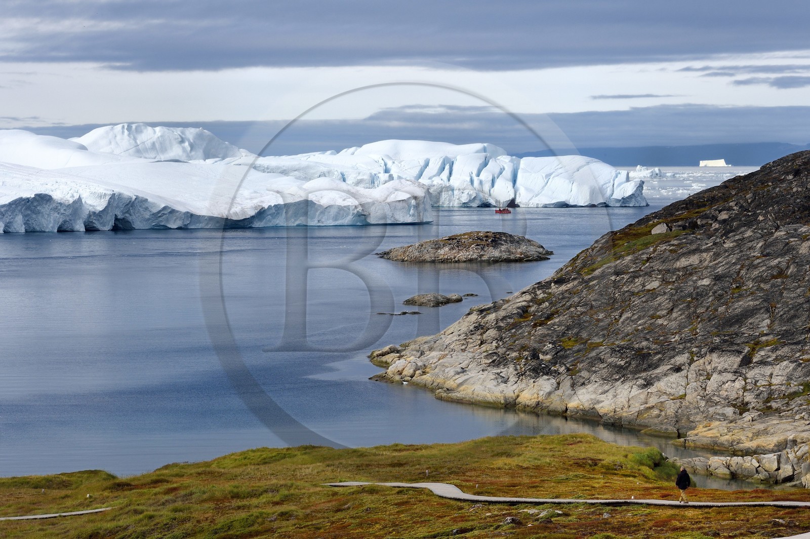 Groenland, cote ouest, baie de Disko, Ilulissat, fjord glacé classé Patrimoine Mondial de l'UNESCO qui est l’embouchure maritime du glacier Sermeq Kujalleq (Jakobshavn Glacier), passerelle en bois du chemin de randonnée allant sur le site de Sermermiut et bateau de pêche au pied des icebergs