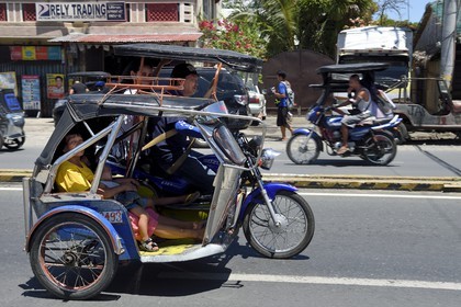 Philippines, province de Nueva Ecija, San José, tricycle moto-taxi dans la rue principale