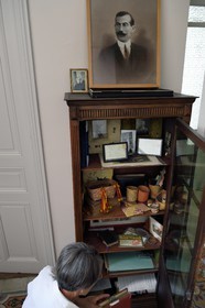 France, Alpes-de-Haute-Provence (04), vallée de l'Ubaye, Jausiers,  Villa mexicaine connue sous le nom de Villa San Carlos, Sophie Meche-Fortoul petite fille de Eugène Fortoul (en portrait dans le cadre) qui émigra au Mexique au début du XXème siècle, armoire aux souvenirs de son aventure
