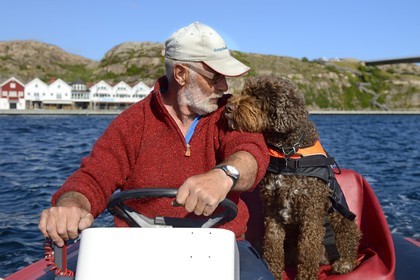 Suède, Västra Götaland, Smögen, Cyril et son chien Simpson à bord de son zodiac