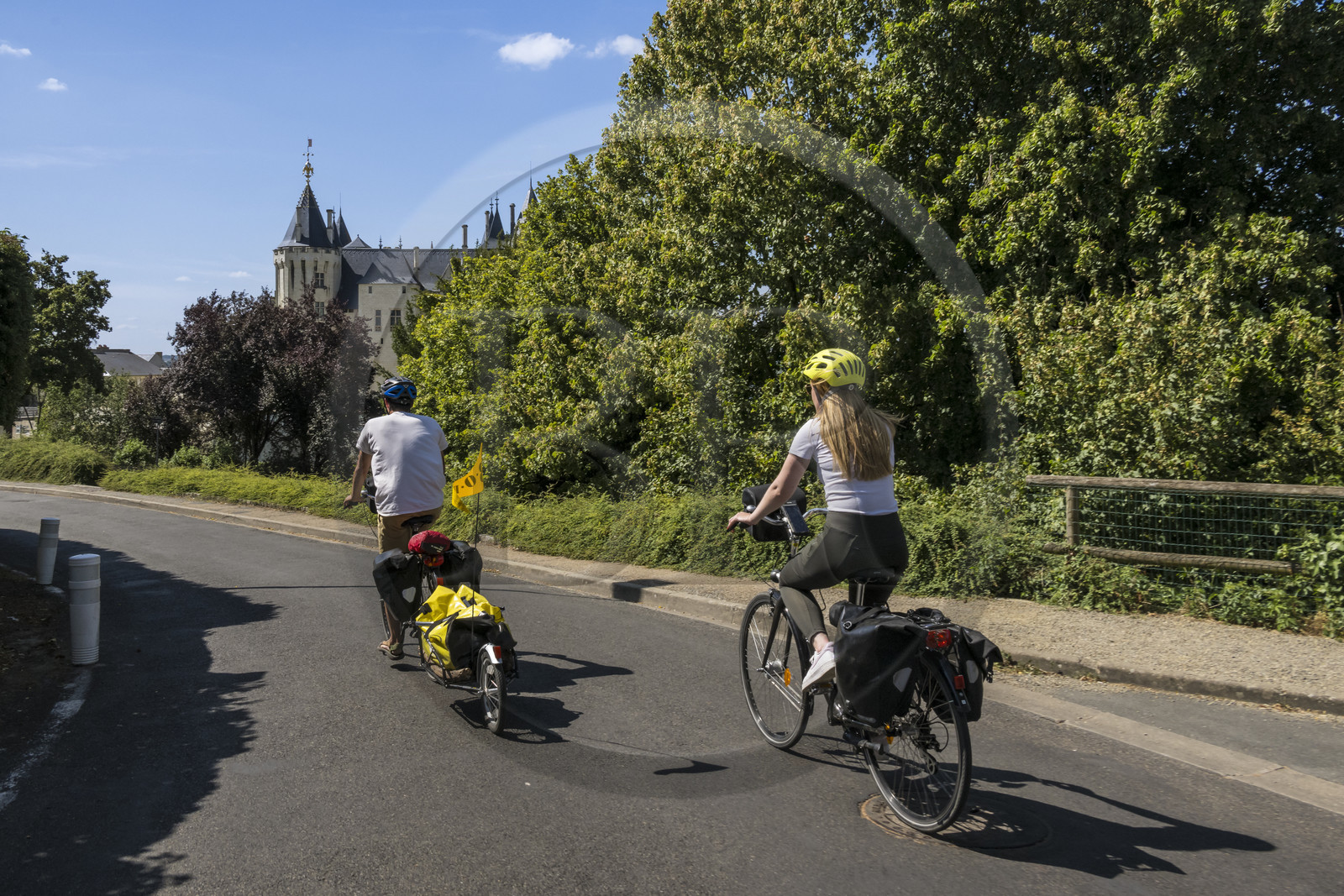 France, Maine-et-Loire (49), vallée de la Loire classée au Patrimoine Mondial par l'UNESCO, Saumur, randonnée à bicyclette sur les berges de la Loire, vélo avec une remorque transportant le matériel de camping, le chateau en arrière plan