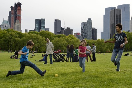 Etats-Unis, New York, Manhattan, Central Park, enfants jouant au football sur le Sheep Meadow, immeubles de Central Park Sud en arrière plan