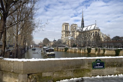 France, Paris (75), les rives de la Seine, classées Patrimoine Mondial de l'UNESCO, la Seine en crue et la Cathédrale Notre-Dame sous la neige sur l'Ile de la Cité et le quai de l'Archevêché vue depuis le pont de l'Archevêché