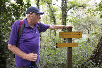 France, Yonne (89), la vallée de la rivière Cousin entre Pontaubert et Avallon, Hervé Desruelles, agriculteur retraité et responsable du club de randonnée Terre de Légendes, passant devant le panneau du GR 213 de Vézelay à l'Abbaye de Fontenay