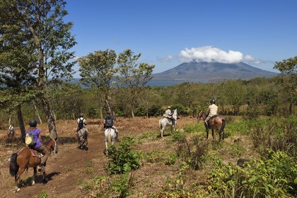 Nicaragua, Ile d'Ometepe sur le lac Nicaragua, cavaliers en randonnée et le volcan Conception (1610 m) toujours en activité en arrière plan