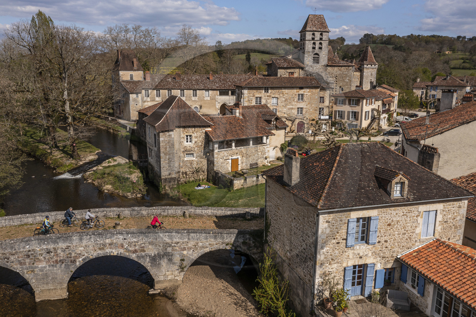 France, Dordogne (24), Périgord Vert, Saint-Jean-de-Côle, labellisé Les Plus Beaux Villages de France, cyclistes faisant la véloroute la Flow Vélo franchissant le pont médiéval du XIIème siècle, le clocher de l'église Saint-Jean-Baptiste (vue aérienne)