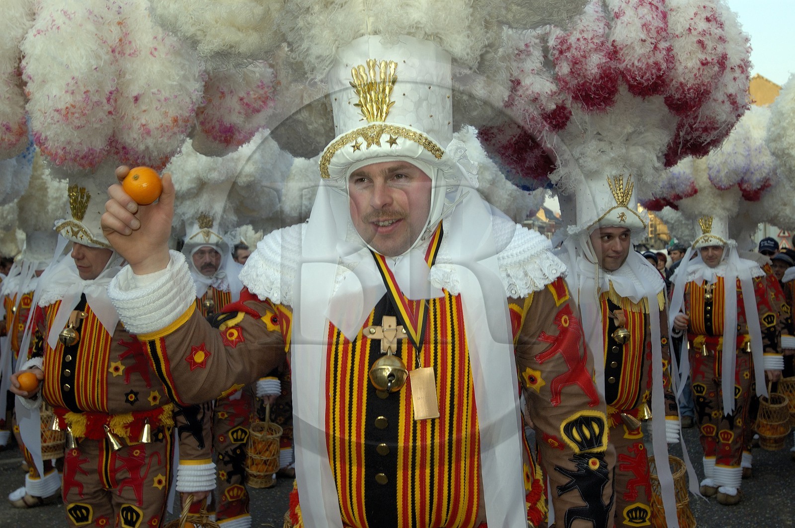 Belgique, Wallonie, carnaval de Binche, Gilles de Binche en procession avec leur coiffe lançant des oranges