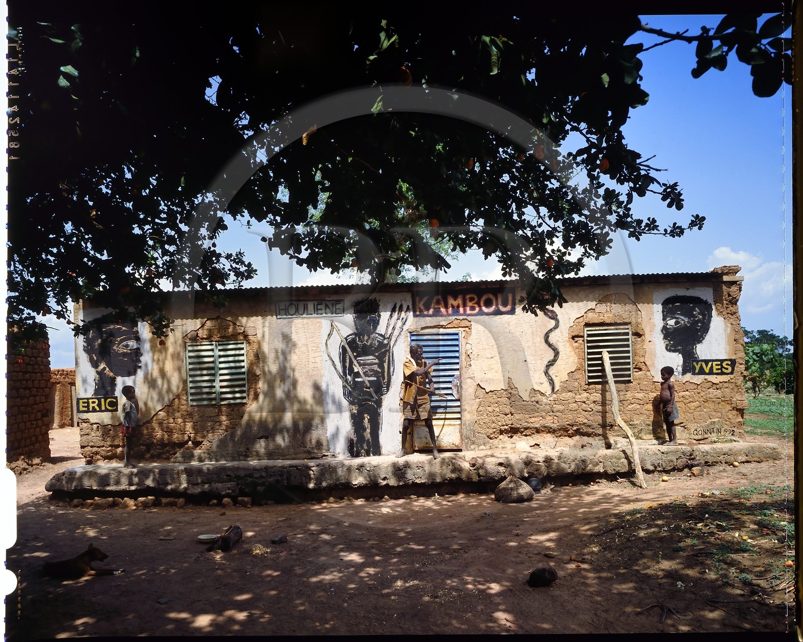 Burkina Faso, province de Poni, pays des Lobi, Loropéni, le vieux Houliene Kambou avec ses petits fils jumeaux, peinture murale de l'artiste Hans Bouman en 1992
