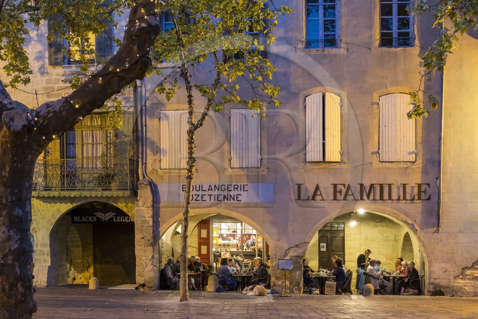 France, Gard (30), Uzès, la Place aux Herbes entourée de maisons à arcades et ses terrasses de café