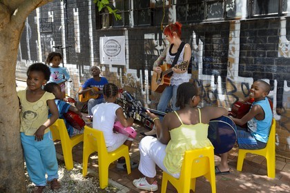 Afrique du Sud, province de Gauteng, Johannesburg, CBD (Central Business District), quartier de Maboneng, Sidewalk Sessions dans Fox street, Kelly Grevler donne des cours de guitare gratuits pour de jeunes enfants dans la rue
