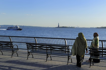 Etats-Unis, New York, Manhattan, pointe Sud, femmes voilée en promenade sur Battery Park et la Statue de la Liberté en arrière plan