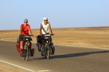 Egypte, désert libyque, couple de touristes cyclistes sur la route du Caire à Bahareyya