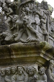 France, Finistère (29), Guimiliau, le calvaire dans l'enclos paroissial, selon la légende la jeune servante katell Gollet est vouée au flammes éternelles car elle aurait dissimulé ses écarts de conduite en confession et commis le sacrilège de dérober une hostie consacrée qu'elle a offerte à Satan qui se cachait sous les traits de son amant