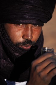 Libye, région du désert, Le Fezzan (Sahara), un touareg en costume traditionnel boit un thé à la menthe