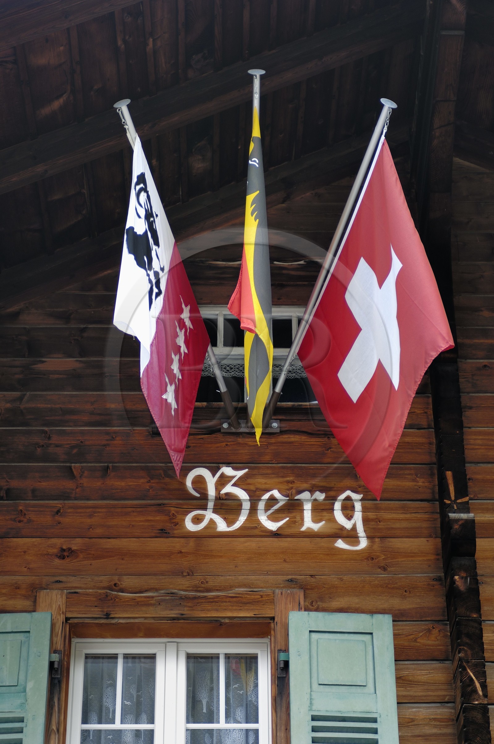 Suisse, Canton de Berne, Oberland Bernois, village de Mürren, chalet traditionnel avec les drapeaux de l'Oberland Bernois et de la Suisse