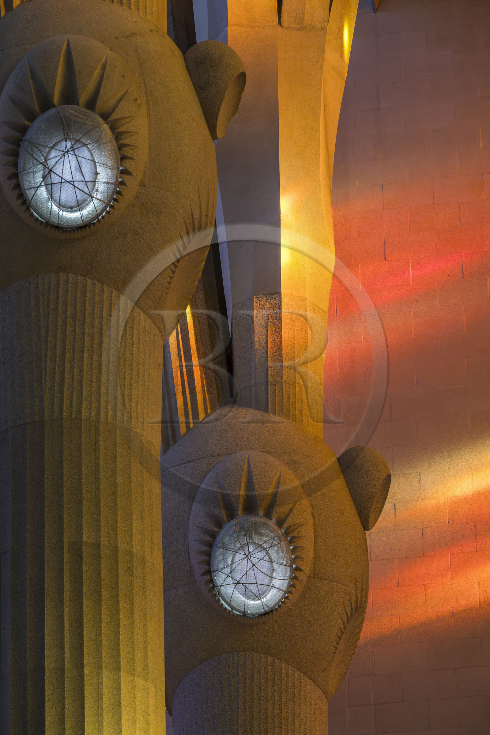 Espagne, Catalogne, Barcelone, quartier de l'Eixample, basilique de la Sagrada Familia de l'architecte du modernisme catalan Antoni Gaudi classée Patrimoine Mondial de l'UNESCO, au dessus du noeud, les colonnes du vaisseau central (nef) se subdivisent en branches tel un arbre, éclairées par les projections chaudes des vitraux du coté de la facade de la Passion