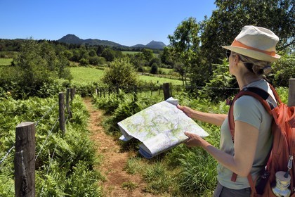 France, Puy-de-Dôme (63), Le Bouchet, Parc naturel régional des Volcans d'Auvergne, randonneuse sur le sentier des puys de Jumes et de la Coquille, en arrière plan le volcan le Puy Chopine à gauche et le Puy de Dome à droite