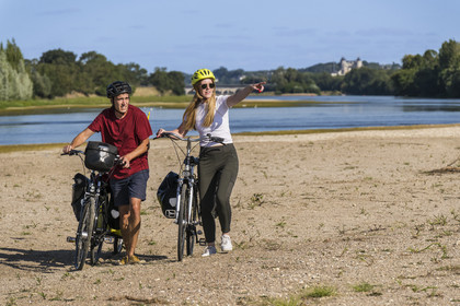 France, Maine-et-Loire (49), vallée de la Loire classée au Patrimoine Mondial par l'UNESCO, Saumur vers Saint-Hilaire, bancs de sable formant des îles sur la Loire et le chateau de Saumur en arrière plan, randonnée à bicyclette sur les berges de la Loire, vélo avec une remorque transportant le matériel de camping