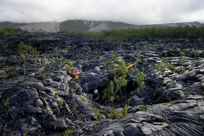 France, Ile de la Reunion, volcan du Piton de la Fournaise, classé Patrimoine Mondial de l'UNESCO, le Grand-Brûlé, coulée de lave récente au pied du volcan, pompier à l'entrée d'un tunnel de lave à l'occasion d'un exercice de sauvetage