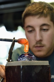 France, Moselle (57), Meisenthal, Centre international d’Art verrier (CIAV), l'atelier de soufflage, fabrication artisanale d'une boule de Noël, pose de la pastille pour la création du crochet en verre