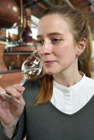 France, Charente (16), Sireuil, Distillerie des Moisans, la responsable du développement des activités commerciales Laurette Didière sent l'eau-de-vie de vin qui deviendra du cognac