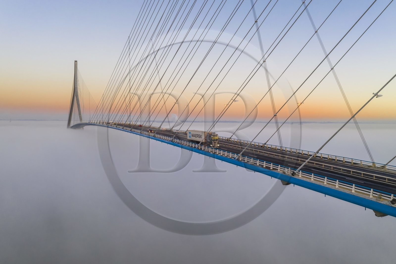 France, entre Calvados (14) et Seine-Maritime (76), le Pont de Normandie émerge des brumes matinales de l'automne et enjambe la Seine pour relier les villes de Honfleur et du Havre