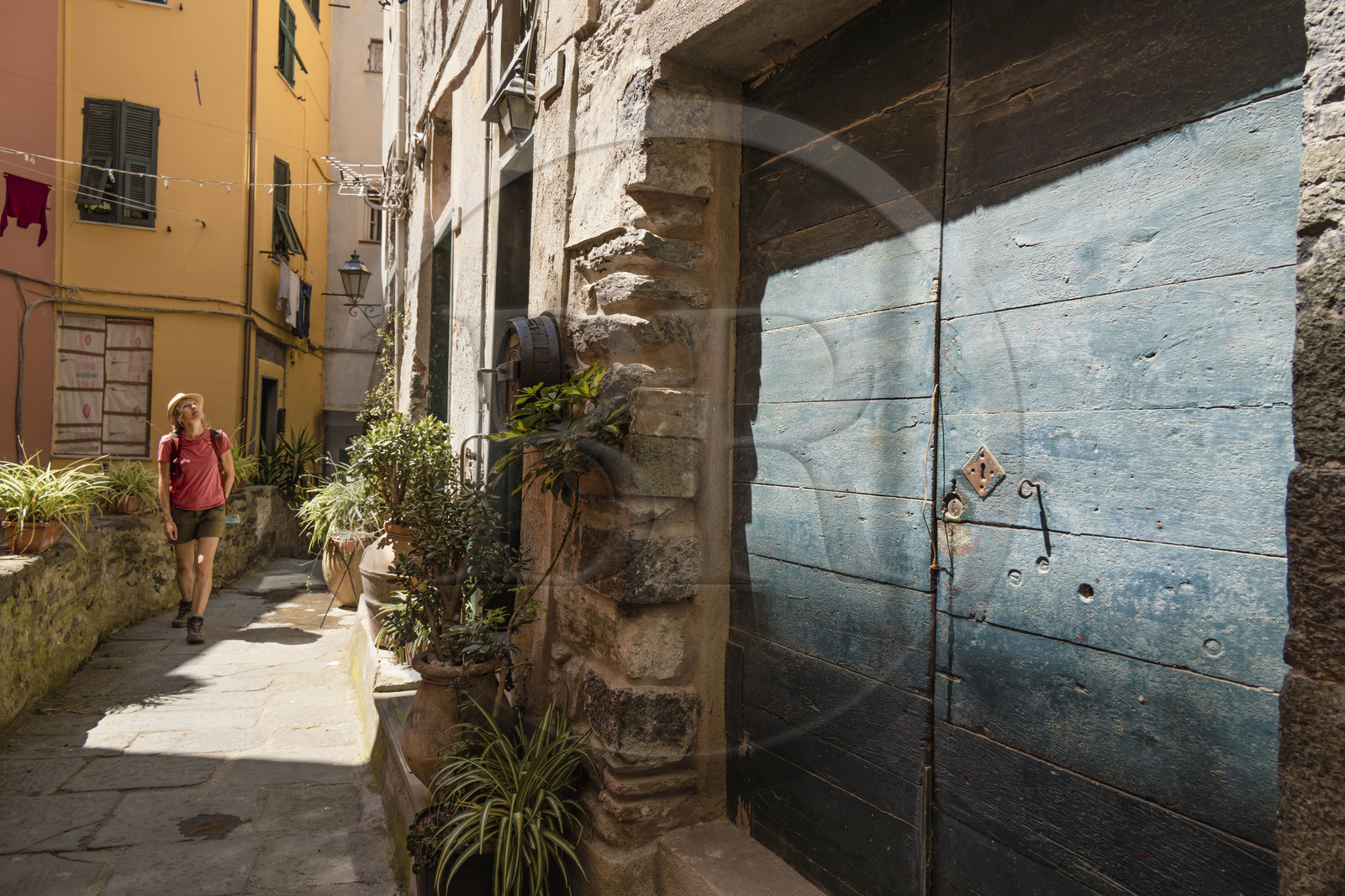 Italie, Ligurie, Cinque Terre, parc national des Cinque Terre classé Patrimoine Mondial de l'UNESCO, randonneuse traversant le village de Vernazza
