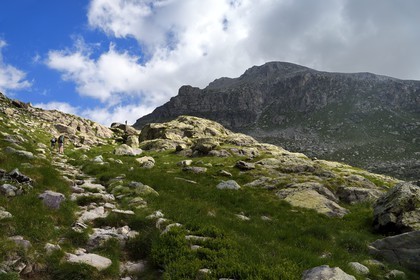 France, Alpes-Maritimes (06), parc national du Mercantour, Vallée des Merveilles parsemée de milliers de gravures rupestres de l'Age de bronze, randonneurs sur le sentier de randonnée GR 52 et le Mont Bégo (2872m) en arrière plan