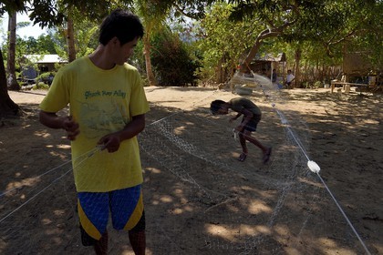 Philippines, Calamian Islands dans le nord de Palawan, Uson Island dans la baie de Coron, village de Barangay Lajala, réparation des filets dans le quartier des pêcheurs