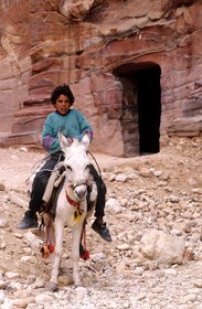 Jordanie, Petra, jeune bédouin devant la façade d' Une tombe dans le Sîq extérieur