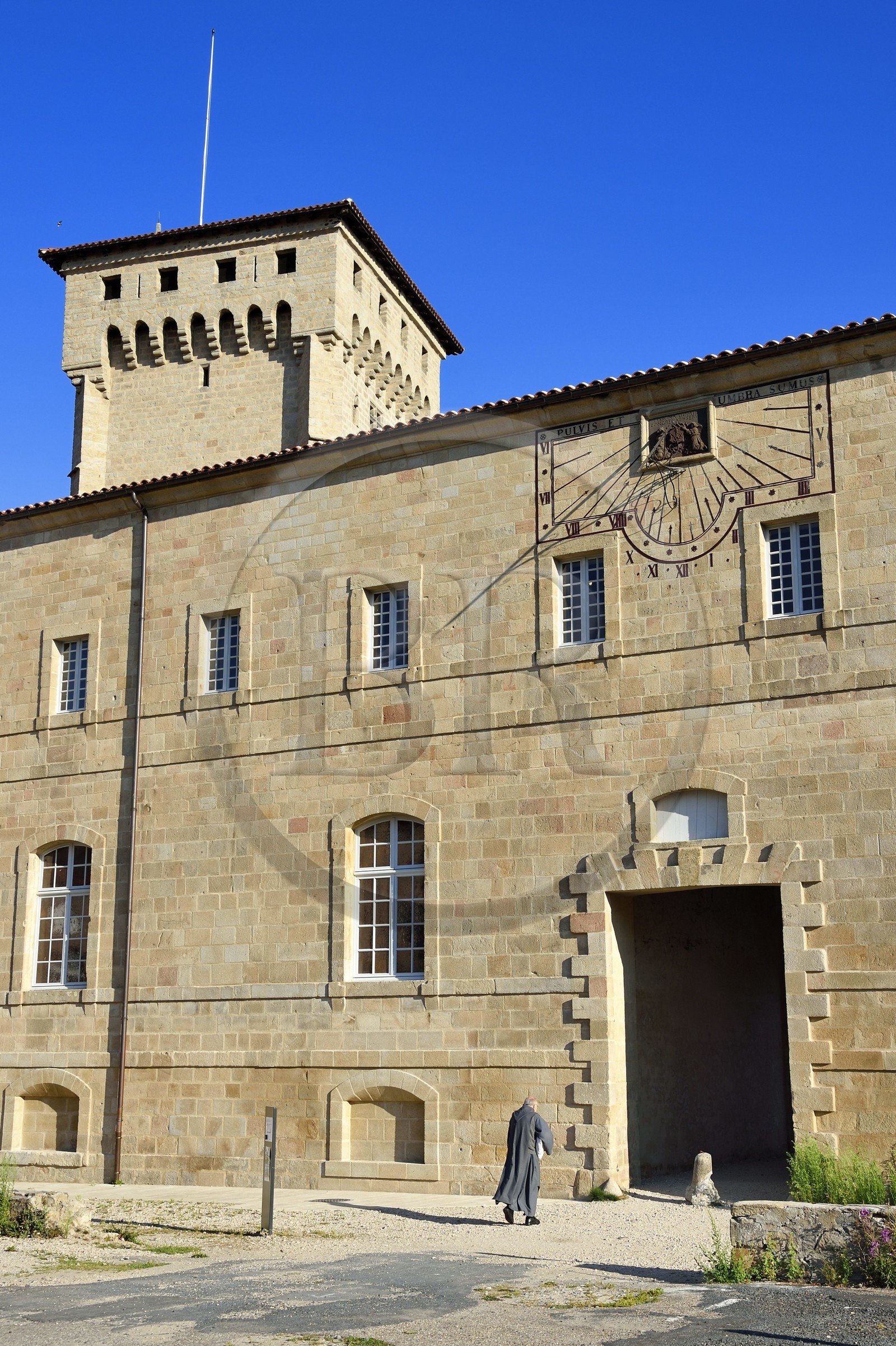 France, Haute-Loire (43), Parc naturel régional Livradois-Forez, un frère de Saint-Jean entre dans l'abbaye de La Chaise-Dieu, la tour Clémentine en arrière plan