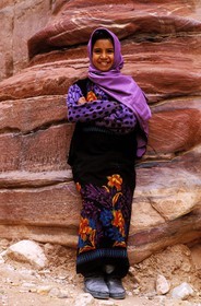 Jordanie, Petra, jeune bédouine devant la façade des tombes dans le Sîq extérieur