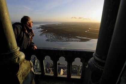 France, Manche (50), Mont-Saint-Michel, classé Patrimoine Mondial de l'UNESCO, monsieur Antoine Bacchiarotti observant le chevet et la baie vus depuis la flèche à l'aube