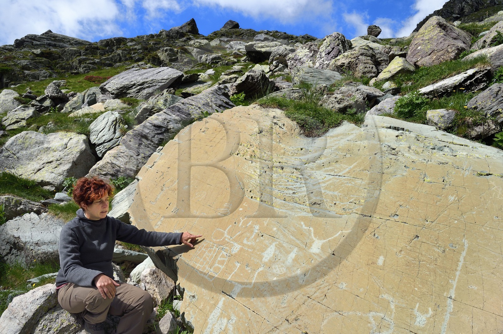 France, Alpes-Maritimes (06), parc national du Mercantour, Vallée des Merveilles parsemée de milliers de gravures rupestres de l'Age de bronze, l'archéologue Nicoletta Bianchi étudie la Roche de l’Eclat gravée de figures corniformes, de poignards et d'un grand réticulé qui symboliserait les champs cultivés