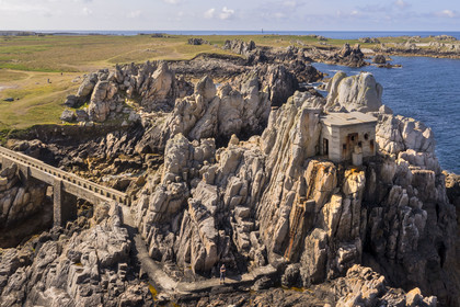 France, Finistère (29), Mer d'Iroise, Ile d'Ouessant, rochers façonnés par les tempêtes au pied du phare du Créac’h, pont menant au batiment de l'ancienne corne de brume (vue aérienne)
