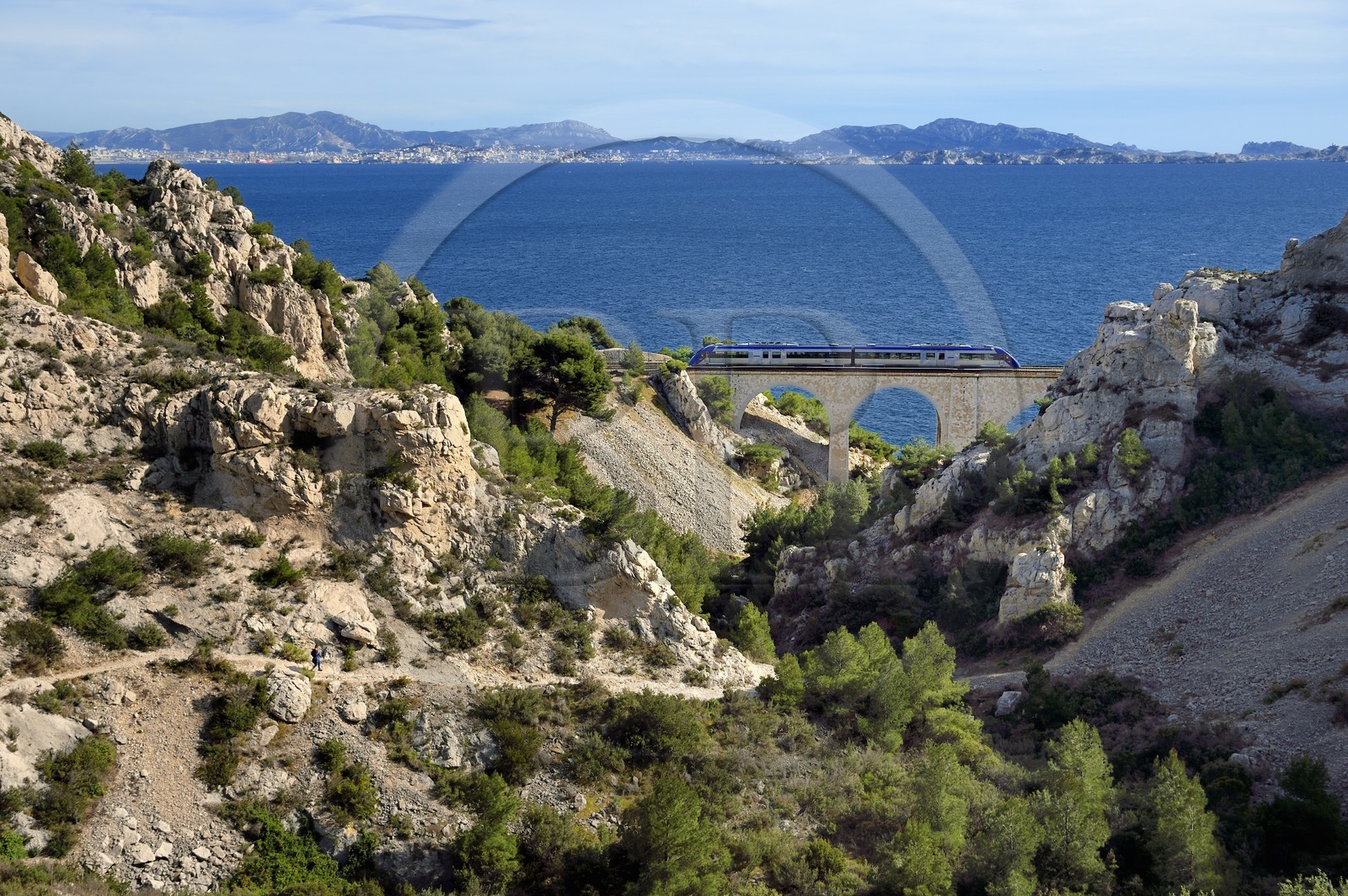 France, Bouches-du-Rhône (13), Le Rove vers Marseille, la Cote Bleue, randonnée de Niolon au Cap Méjean le long du Sentier des Douaniers, randonneur descendant vers le pont ferroviaire de la calanque du Jonquier et la ville de Marseille en arrière plan