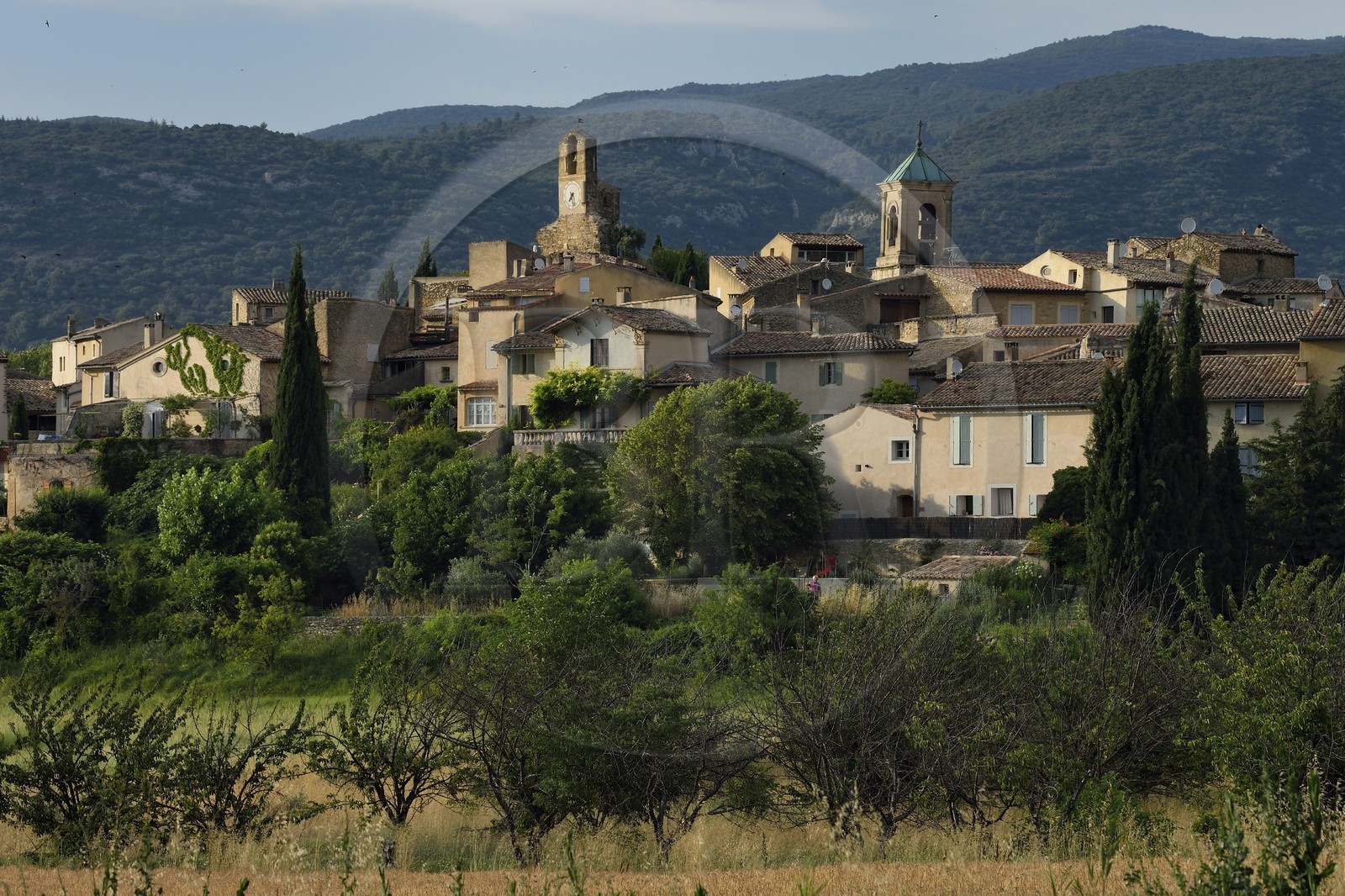France, Vaucluse (84), Parc Naturel Regional du Luberon, Lourmarin, labellisé Les Plus Beaux Villages de France, la Tour de l'horloge et le chocher de l'église, le massif du Lubéron en arrière-plan