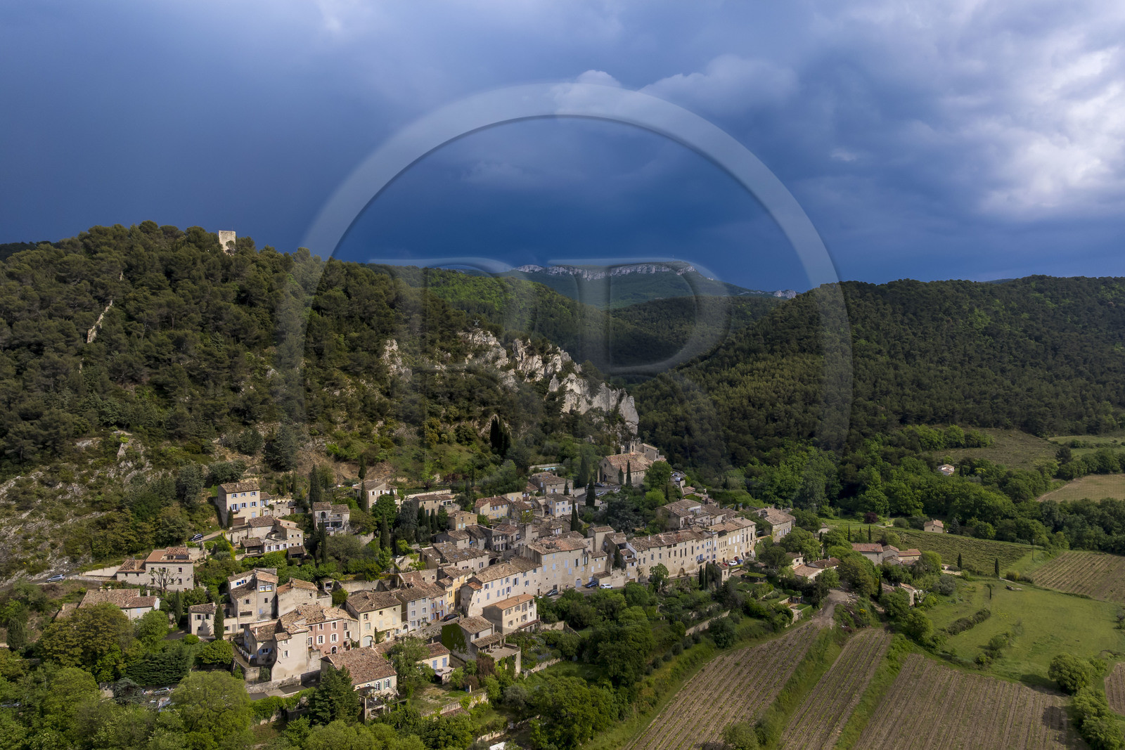 France, Vaucluse (84), Dentelles de Montmirail, le village médiéval de Séguret, labellisé Les Plus Beaux Villages de France, un jour d'orage et la crête de Saint-Amand vue du Sud en arrière plan (vue aérienne)