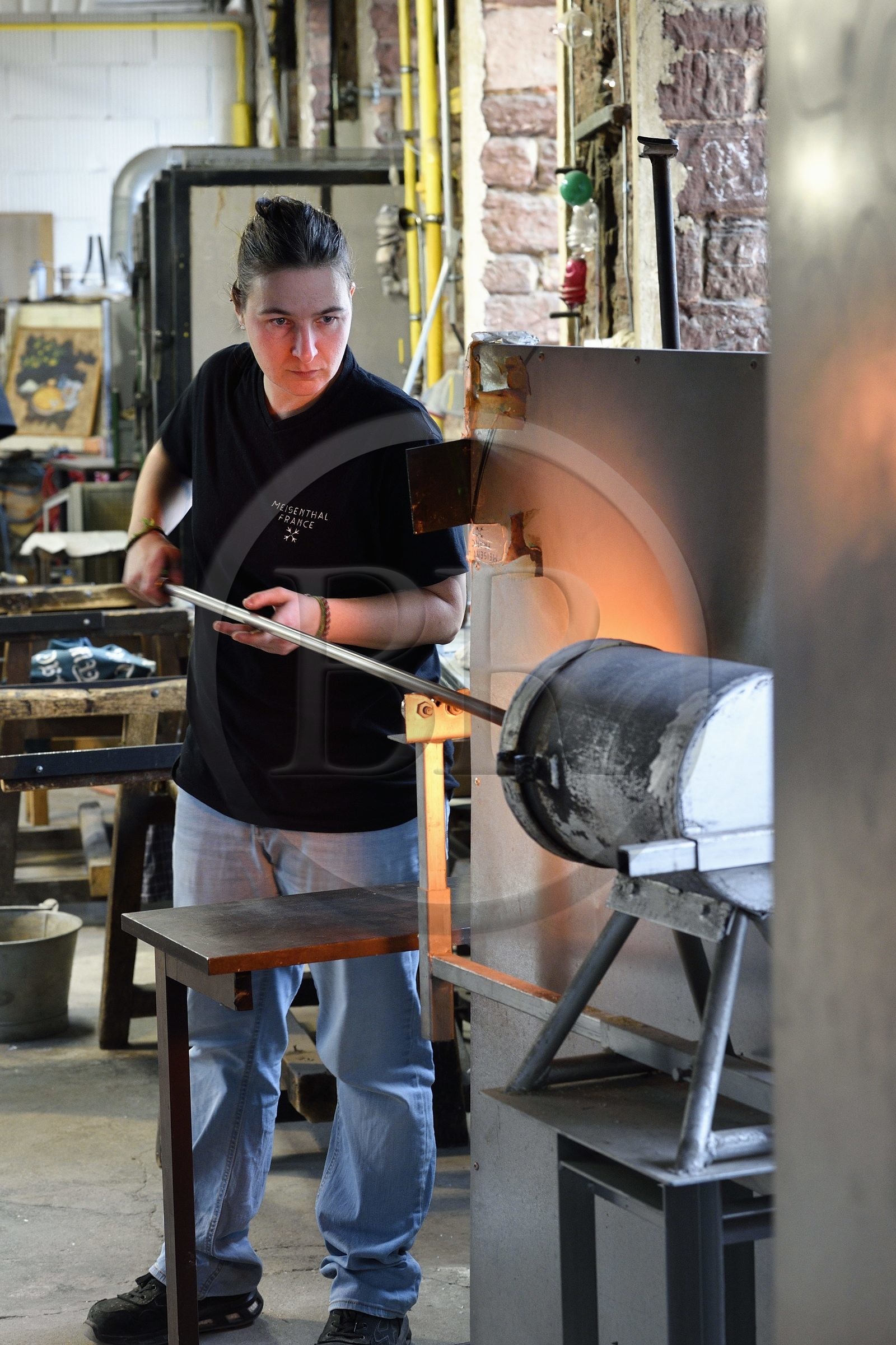 France, Moselle (57), Meisenthal, Centre international d’Art verrier (CIAV), l'atelier de soufflage, fabrication artisanale d'une boule de Noël, le souffleur recueille dans le four une masse de verre en fusion avec sa canne de verrier