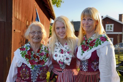 Suède, comté de Dalécarlie, région de Leksand, célébrations du solstice d'été dans le petit hameau de Hjulbäck, trois femmes en costumes traditionnels, grand-mère, mère et fille