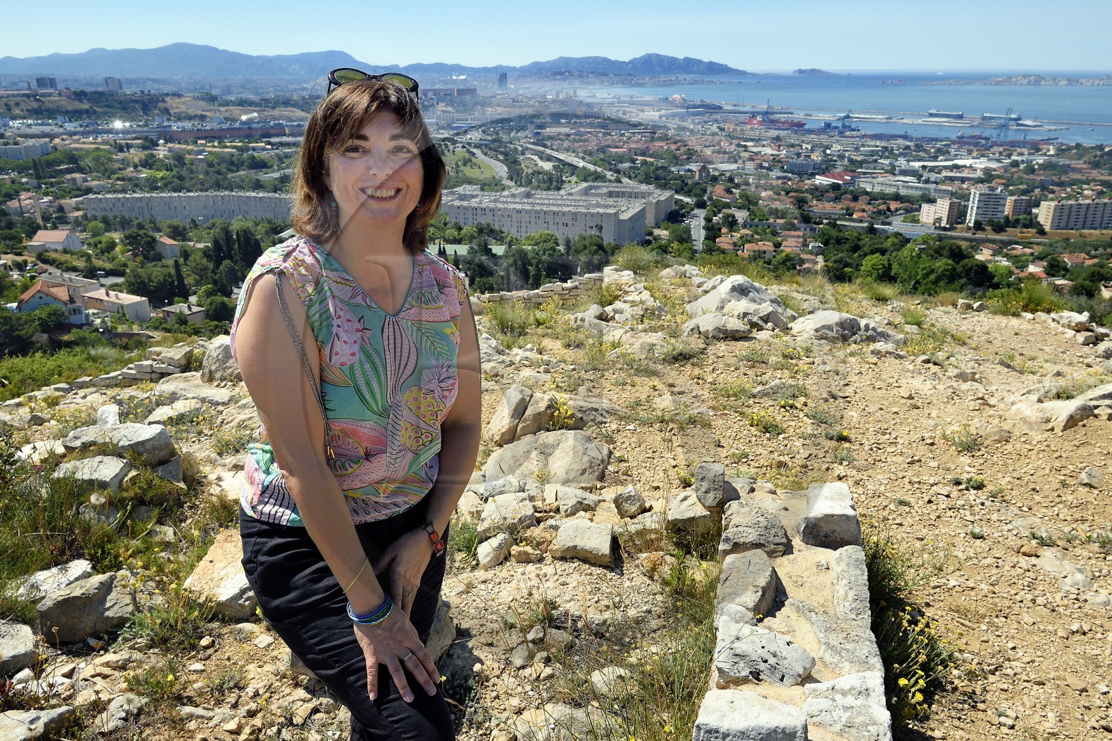 France, Bouches-du-Rhône (13), Marseille, les quartiers Nord, site archéologique celto-ligure de l'oppidum de Verduron fondé à la fin du IIIe siècle av. J.-C au premier plan, la Cité Castellane et le Grand Port Maritime en arrière plan, l'archeologue Nathalie Cazals