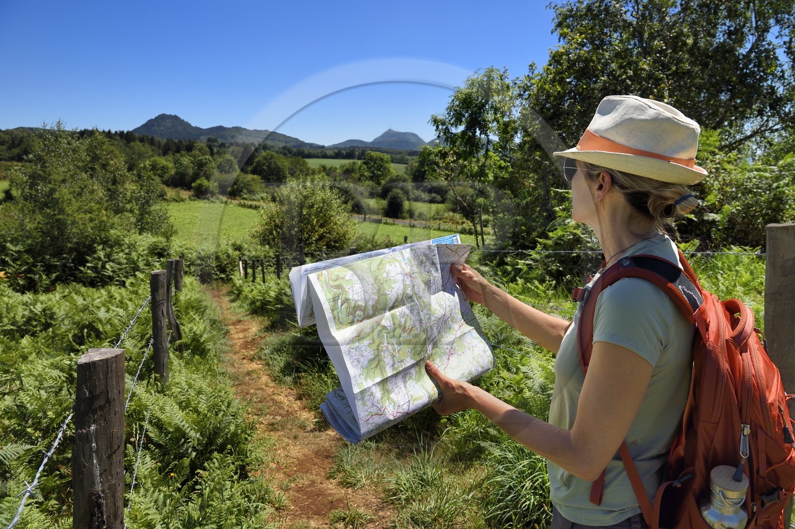 France, Puy-de-Dôme (63), Le Bouchet, Parc naturel régional des Volcans d'Auvergne, randonneuse sur le sentier des puys de Jumes et de la Coquille, en arrière plan le volcan le Puy Chopine à gauche et le Puy de Dome à droite