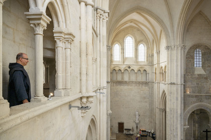 France, Yonne (89), parc naturel régional du Morvan, Vézelay, classé au Patrimoine Mondial de l'UNESCO, labellisé Les Plus Beaux Villages de France, point de départ de l'une des principales voies de pèlerinage de Saint-Jacques-de-Compostelle, la basilique Sainte-Marie-Madeleine, le frère Matteo de la Fraternité de Jérusalem en tunique et chasuble noir dans le triforium surplombant le transept